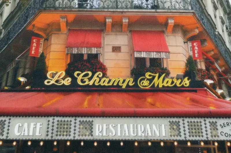 Le café Le Champ de Mars et un immeuble haussmannien à balcons, Paris 7e